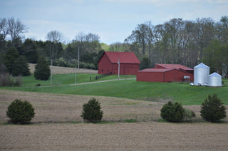 red and white barn house near green trees under white sky during daytime
