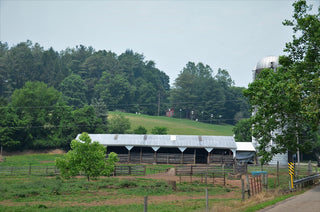 a farm with a barn and a silo in the background