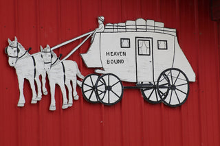 A wooden sign depicts a stagecoach labeled heaven bound.
