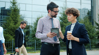 Two business people discussing a tablet outdoors